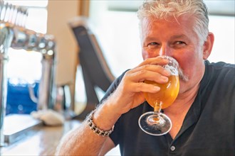 Handsome man tasting A glass of micro brew beer