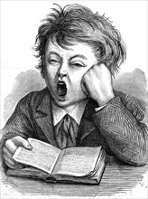 Boy yawning while reading
