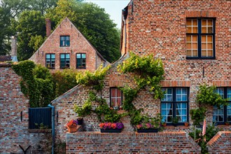 Old houses of Begijnhof Beguinage with flowers in Bruges town