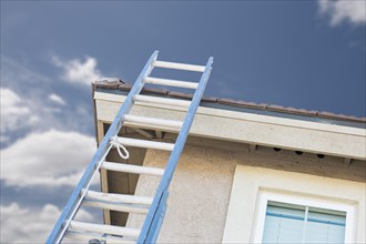 Aluminum construction ladder leaning against house