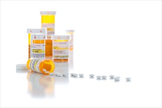 Non-Proprietary medicine prescription bottles and spilled pills isolated on a white background