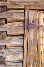 Abstract of vintage antique log cabin wall and door with hinge
