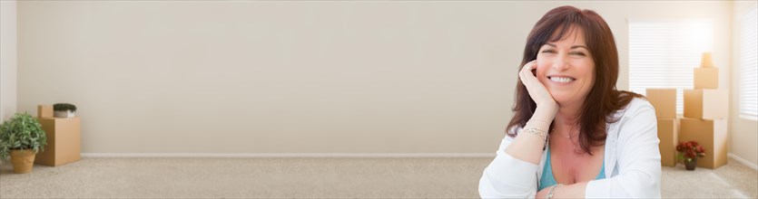 Banner of middle aged woman relaxing inside empty room with moving boxes