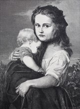 A child holds his sister in his arms