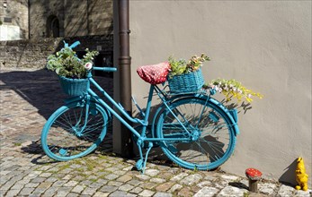 Old painted bicycle with flower decoration in an alley of the historic old town of the imperial palace Bad Wimpfen