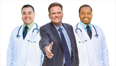 Two mixed-race doctors behind businessman reaching for a hand shake isolated on white