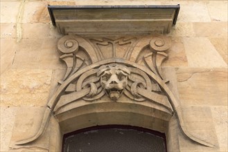 Art Nouveau ornaments with lion's head above an entrance door of a residential house