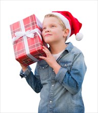 Curious young boy wearing santa hat holding christmas gift isolated on a white background