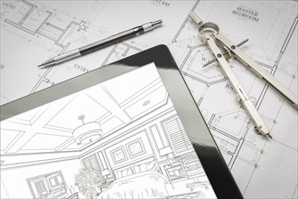 Computer tablet showing room illustration sitting on house plans with pencil and compass