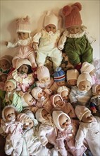 Various decorative dolls and baby dolls lying together