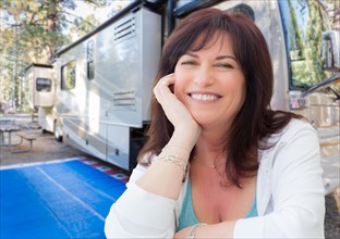 Attractive middle aged woman outdoor portrait in front of class A RV