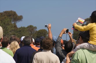 Fans huddle to get a glimpse of tiger woods warming up at the golf range