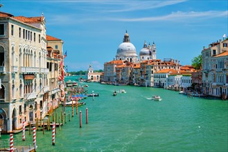 View of Venice Grand Canal with boats and Santa Maria della Salute church in the day from Ponte dell'Accademia bridge Venice