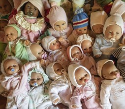 Various decorative dolls and baby dolls lying together