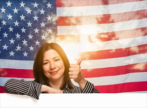 Hispanic woman with thumbs up in front of american flag