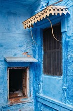 Windows in blue house facade in streets of of Jodhpur