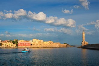 Fishing boat going to sea in picturesque old port of Chania is one of landmarks and tourist destinations of Crete island in the morning. Chania