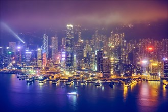 Aerial view of illuminated Hong Kong skyline cityscape downtown skyscrapers over Victoria Harbour in the evening. Hong Kong