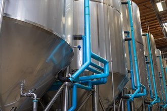 Large beer brewery fermentation tanks in warehouse
