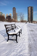Empty snowy bench in chicago after winter snow along lake shore drive