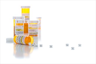 Non-Proprietary medicine prescription bottles and spilled pills isolated on a white background