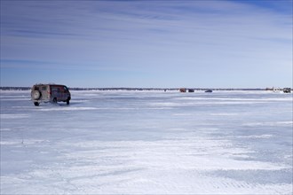 Car on a wide and frozen riverscape
