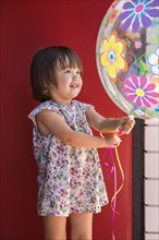 Toddler girl holding a big balloon