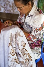 Balinese woman making a batik in Tohpati