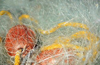 White fishing net with yellow rope and red float