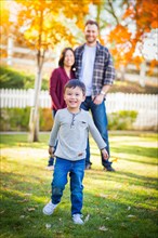 Outdoor portrait of happy mixed-race chinese and caucasian parents and child