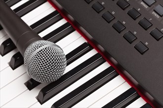 Microphone laying on electronic synthesizer keyboard abstract
