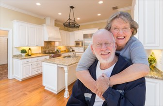 Happy loving senior couple hugging inside custom kitchen