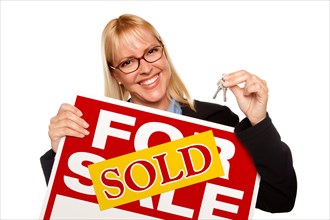 Attractive blonde holding keys & sold for sale sign isolated on a white background
