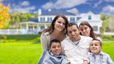 Happy young hispanic family in front of their new home