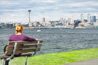 Woman sitting on bench looking at the seattle