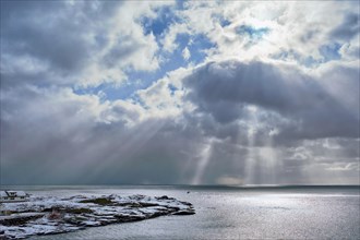 Norwegian sea in winter with sun rays through clouds. Lofoten islands