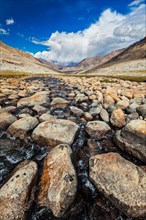Mountain stream with stones in Himalayas near Khardung La pass. Ladakh
