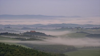 Sunrise with foggy atmosphere in the hilly landscape