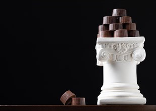 Stack of fine artisan chocolates stacked on white pillar column