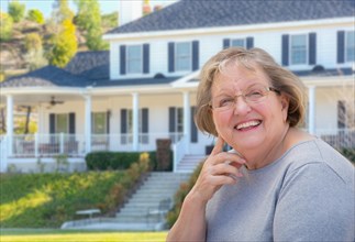 Senior adult woman in front of beautiful house