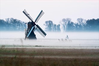 Morning atmosphere with windmill and cyclist