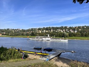 View over a rowing club and boat jetty to the Elbe and a steamer
