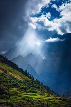 Sun rays through clouds in Himalayan valley in Himalayas. Lahaul valley