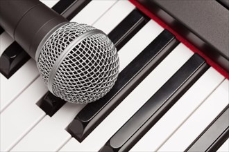 Microphone laying on electronic synthesizer keyboard abstract