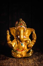 Ganesha statue isolated on wooden background