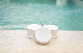Close-up of some chlorine tablets for cleaning on the edge of a swimming pool