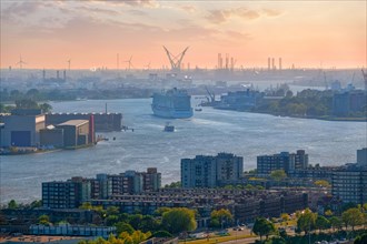 View of Rotterdam port and Nieuwe Maas river with cruise liner ship on sunset