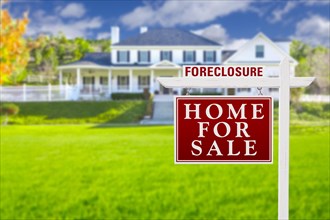 Foreclosure home for sale real estate sign in front of beautiful majestic house