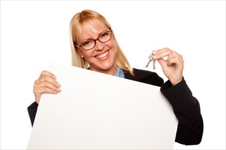 Attractive blonde holding keys and blank white sign isolated on a white background