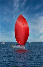 Sailing boat with red sail